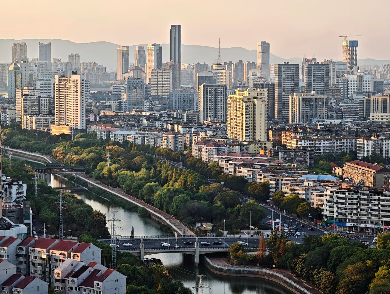 High angle view of a sprawling city with modern skyscrapers at dusk, showcasing urban landscape.